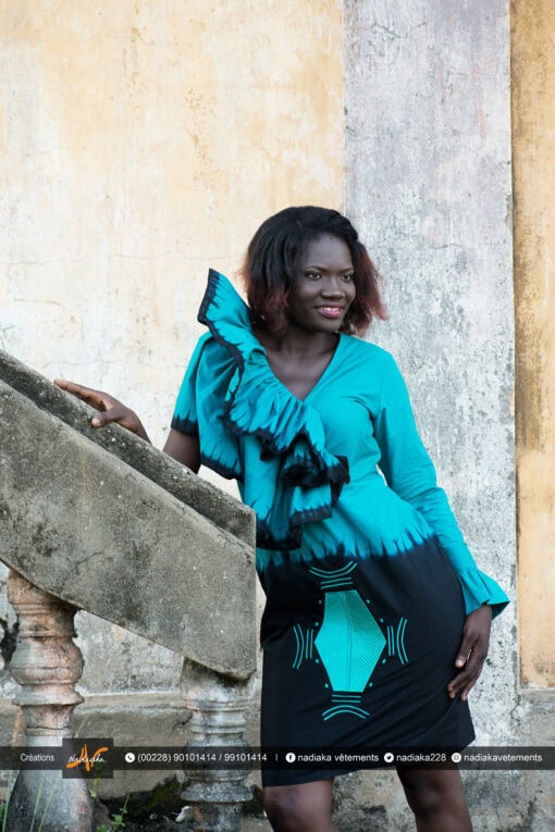 Robe batik vert émeraude noire, brodée, manches asymétriques à volants superposés.