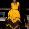 Robe longue brodée "Adétèdou séwloué", tissu batik tons orange et marron, ceinture brodée assortie.