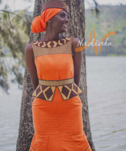 Robe longue brodée, en pagne tissé orange à brillantine or, Avec ceinture large brodée. Foulard et chapeau brodé assortis.