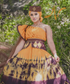 Robe longue, haut drapé, en tissu batik couleur moutarde et marron. Avec ceinture large brodée et tulles traîne brillant marron. Foulard et chapeau brodé assortis.