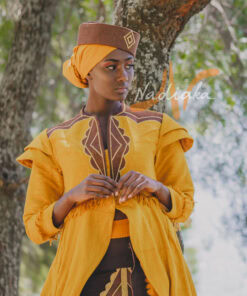 Robe longue brodée à traîne, en pagne tissé couleur moutarde à brillantine or. Jupe en tissu batik marron Foulard et chapeau brodé assortis.