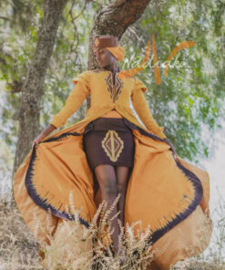 Robe longue brodée à traîne, en pagne tissé couleur moutarde à brillantine or. Jupe en tissu batik marron Foulard et chapeau brodé assortis.