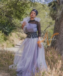 Robe longue, en pagne tissé couleur argentée, à brillantine argent, mix tulles brillant argent et dentelles noires. Avec ceinture large brodée et froufrous. Foulard et chapeau brodé assortis.