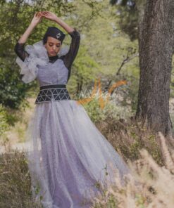 Robe longue, en pagne tissé couleur argentée, à brillantine argent, mix tulles brillant argent et dentelles noires. Avec ceinture large brodée et froufrous. Foulard et chapeau brodé assortis.