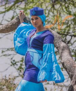 Robe longue volantée, brodée, en pagne tissé à brillantine, mix tissu batik couleur bleue turquoise et bleu. Avec ceinture large asymétrique brodée. Foulard et chapeau brodé assortis.