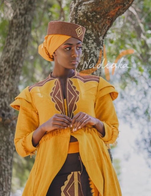 Robe longue brodée à traîne, en pagne tissé couleur moutarde à brillantine or. Jupe en tissu batik marron Foulard et chapeau brodé assortis.