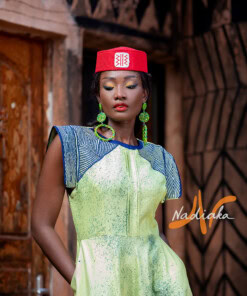 Robe longue de couleur verte, brodée en teinture à jets , ovale de la taille jusqu'au bas assortie d'un chapeau Apéto rouge à motif blanc
