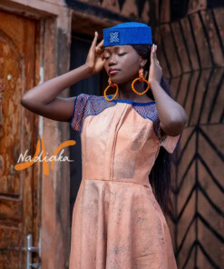 Robe longue ovale en teinture à jets marron assortie avec un chapeau apéto bleu et des boucles d'oreilles en pailles