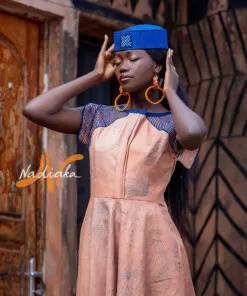Robe longue ovale en teinture à jets marron assortie avec un chapeau apéto bleu et des boucles d'oreilles en pailles