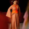 Longue robe de soirée en col V brodée munie d'une ceinture brodée jaune moutarde. Les manches sont longues et asymétriques